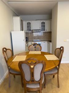 a dining room table with chairs and a kitchen at Mina Apartment in Tirana