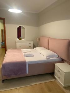 a bedroom with a large bed and a mirror at Mina Apartment in Tirana