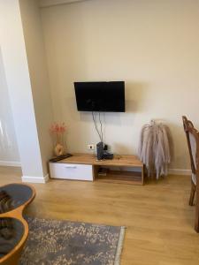 a living room with a flat screen tv on a wall at Mina Apartment in Tirana +5 photos