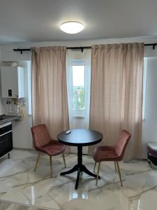 a dining room with a table and two chairs at Pollux Residence Militari ap 113 in Dudu +6 photos