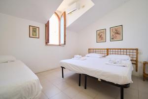 a bedroom with two beds and a window at Villa Liberty Rosa in San Vincenzo