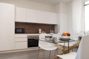 a kitchen with a glass table and white cabinets at Tra il Borgo e il Lago in Lovere