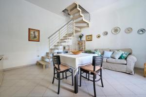 a dining room with a table and a staircase at Villa Liberty Rosa in San Vincenzo +22 photos