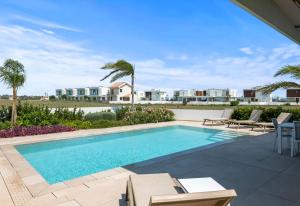 una piscina en un patio con una villa en Serenity Waves Villa 22, en Lárnaca