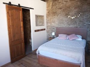 a bedroom with a bed with pink pillows on it at El Petit Paradís in Bellestar