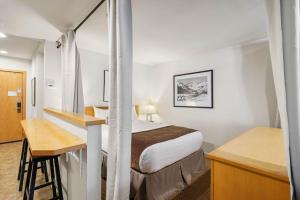Una pequeña habitación de hotel con una cama y un escritorio. en Palisades Tahoe Lodge Rentals Studio Loft #346, en Olympic Valley 14 fotos más