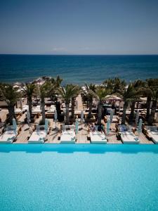 a view of the beach from the pool at a resort at Nikki Beach Resort & Spa Santorini in Kamari