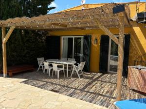 a patio with a table and chairs under a pergola at Holiday Paraiso in Sant Antoni de Calonge