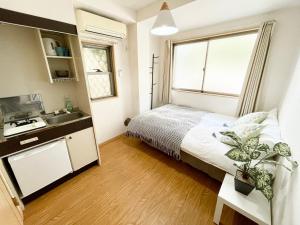 Un dormitorio pequeño con una cama y un lavabo. en シャンテ高田馬場11, en Tokio