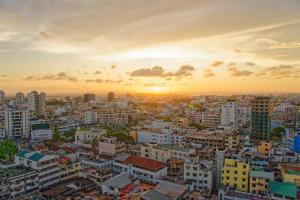 a city skyline at sunset with the sun setting at Seaview Penthouse, AC included & Rooftop Pool in Mombasa