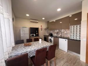 a kitchen with a table and chairs in a room at Time Holiday´s House in Olhão