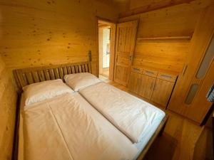 a bed in a wooden room in a cabin at Berghütte am Grandsberg in Schwarzach