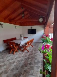 a dining room with a table and chairs and flowers at Casa Miki in Haţeg