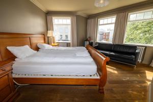 una camera con un grande letto e un divano in pelle di BG4 Guesthouse ad Akureyri