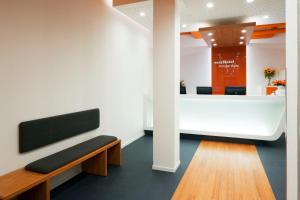 a waiting room with a bench and a reception desk at easyHotel Amsterdam City Centre South in Amsterdam