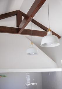 two white lights hanging from a ceiling at Quinta da Costeira - Casa Azul do Limoal by ALPONTE in Arcos de Valdevez