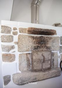 a stone fireplace on a wall in a room at Quinta da Costeira - Casa Azul do Limoal by ALPONTE in Arcos de Valdevez