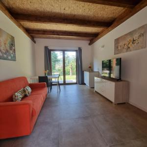 a living room with a red couch and a tv at Villapiana Country House in Pellezzano