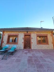 a house with two blue chairs in front of it at "Cal Tu" in San Fausto de Campcentellas