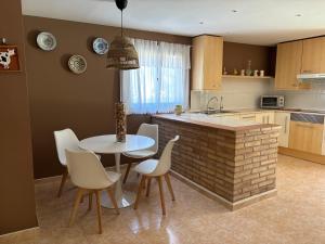 a kitchen with a table and chairs and a kitchen with a sink at Holiday Paraiso in Sant Antoni de Calonge