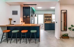 a kitchen with a blue counter and stools at 4 Bedroom Gorgeous Apartment In Medulin in Medulin
