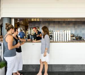 
a woman and a man standing in front of a counter at Mangrove Hotel in Broome
