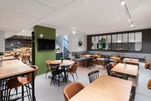 een restaurant met tafels en stoelen en een groene muur bij ibis Paris Italie Tolbiac in Parijs