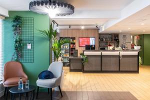 een lobby met groene muren en stoelen en een bar bij ibis Paris Italie Tolbiac in Parijs