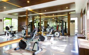 a gym with several treadmills and elliptical machines at Maehaad Bay Resort - SHA Plus in Mae Haad