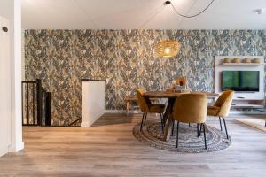 een eetkamer met een tafel en stoelen en behang bij NEW! Fantastic appartments - Duno Lodges 4 persons in Oostkapelle