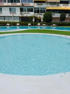 a large pool of blue water in front of a building at Lovely Apartament Taidia in Maspalomas