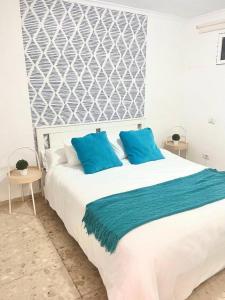 a bedroom with a large bed with blue pillows at Lovely Apartament Taidia in Maspalomas +20 photos
