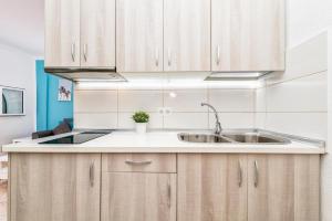 a kitchen with wooden cabinets and a sink at Lovely Apartament Taidia in Maspalomas