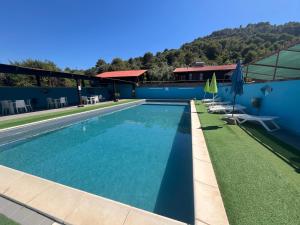 a swimming pool with chairs and a building at Abbamala Village in Bosa