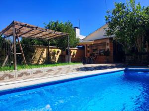 a swimming pool with a pergola next to a house at La Casa del Naturalista in El Bosque