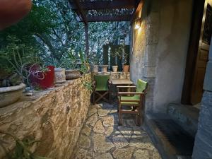 a patio with chairs and a table and some plants at Porfyrousa Traditional Hotel in Milopótamos