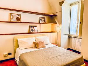 a bedroom with a bed with two pillows and a window at GALA Apartments - Charme Barocco a due passi da Piazza Duomo in Lecce