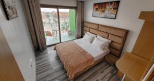 um quarto de hotel com uma cama e uma varanda em Appart-Hotêl Résidence TITANIC em Tiznit