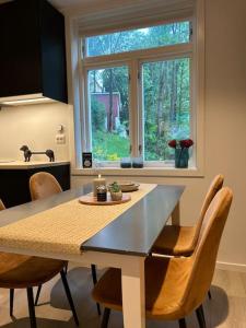a kitchen with a table and chairs and a window at Lite hus 15 min fra Oslo in Høvik