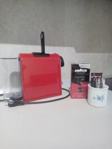 a counter top with a red toaster and a book at ΘωΜΑΙΣ in Glykadi +30 photos