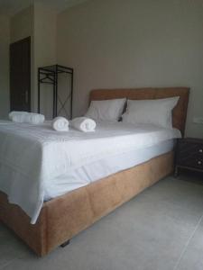 a bedroom with a large bed with towels on it at ΘωΜΑΙΣ in Glykadi