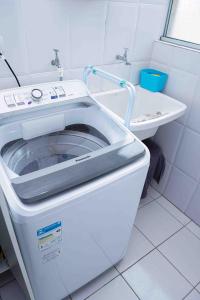 a washing machine in a bathroom with a sink at Menlia Guarujá in Guarujá