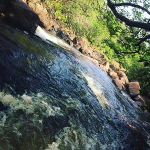 a view of a stream of water with rocks and trees at Pousada Divino Toca in Palmas