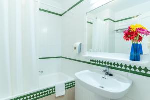 a white bathroom with a sink and a mirror at HOVIMA Jardin Caleta in Adeje