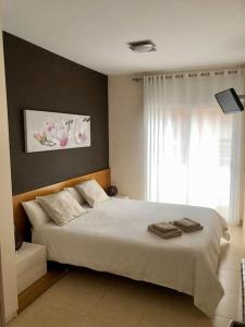 a bedroom with a white bed and a window at The White Lilies in Pineda de Mar