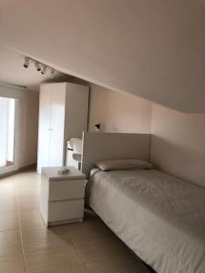 a white bedroom with a bed and a night stand at The White Lilies in Pineda de Mar +14 photos