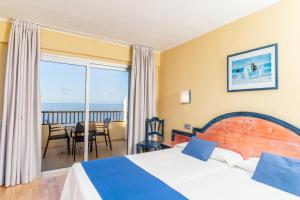 a hotel room with a bed and a view of the ocean at HOVIMA Jardin Caleta in Adeje