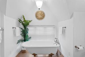 a white bathroom with a tub and a plant at The Uplifting Mansion in Milwaukee +65 photos