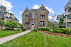 an exterior view of a large brick house with a yard at The Uplifting Mansion in Milwaukee