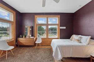 a bedroom with a large bed and two windows at The Uplifting Mansion in Milwaukee